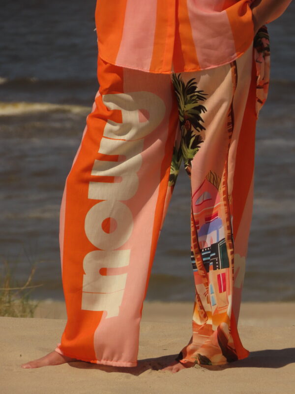 Pantalon Amour ample avec élastique à la taille, imprimé "Amour" sur une jambe et motif bord de mer sur l'autre, rayures roses et oranges