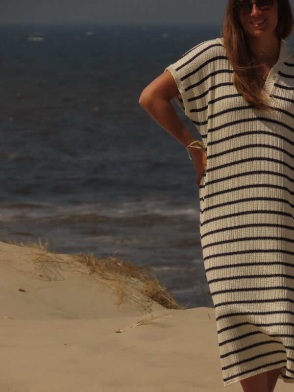 Robe Riviera longue à rayures bleues et blanches avec fente en bas, portée en extérieur lors d'une journée ensoleillée.
