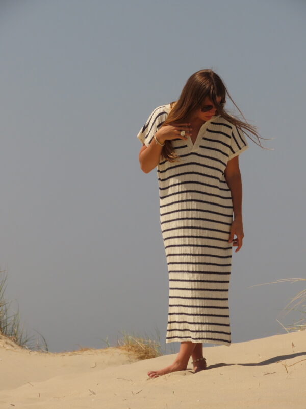 Robe Riviera longue à rayures bleues et blanches avec fente en bas, portée en extérieur lors d'une journée ensoleillée.