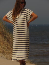Robe Riviera longue à rayures bleues et blanches avec fente en bas, portée en extérieur lors d'une journée ensoleillée.