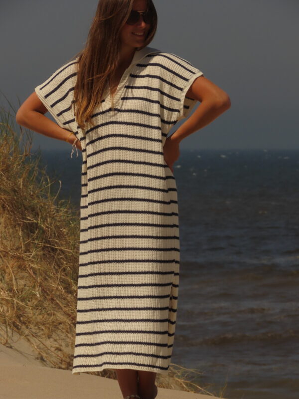 Robe Riviera longue à rayures bleues et blanches avec fente en bas, portée en extérieur lors d'une journée ensoleillée.