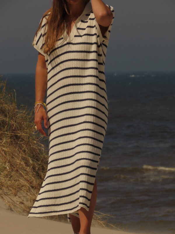 Robe Riviera longue à rayures bleues et blanches avec fente en bas, portée en extérieur lors d'une journée ensoleillée.