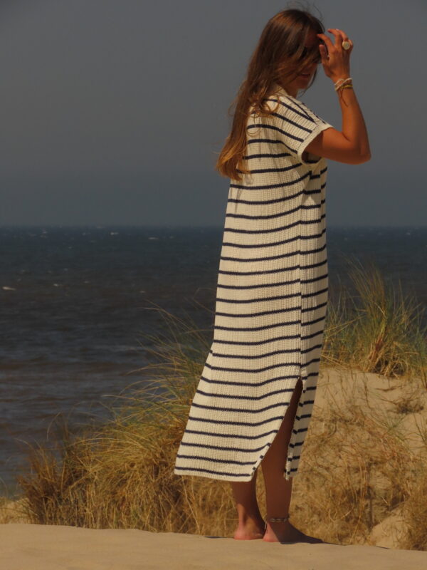 Robe Riviera longue à rayures bleues et blanches avec fente en bas, portée en extérieur lors d'une journée ensoleillée.
