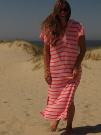 Robe Riviera longue aux teintes rose et orange, portée en extérieur lors d'une journée ensoleillée.